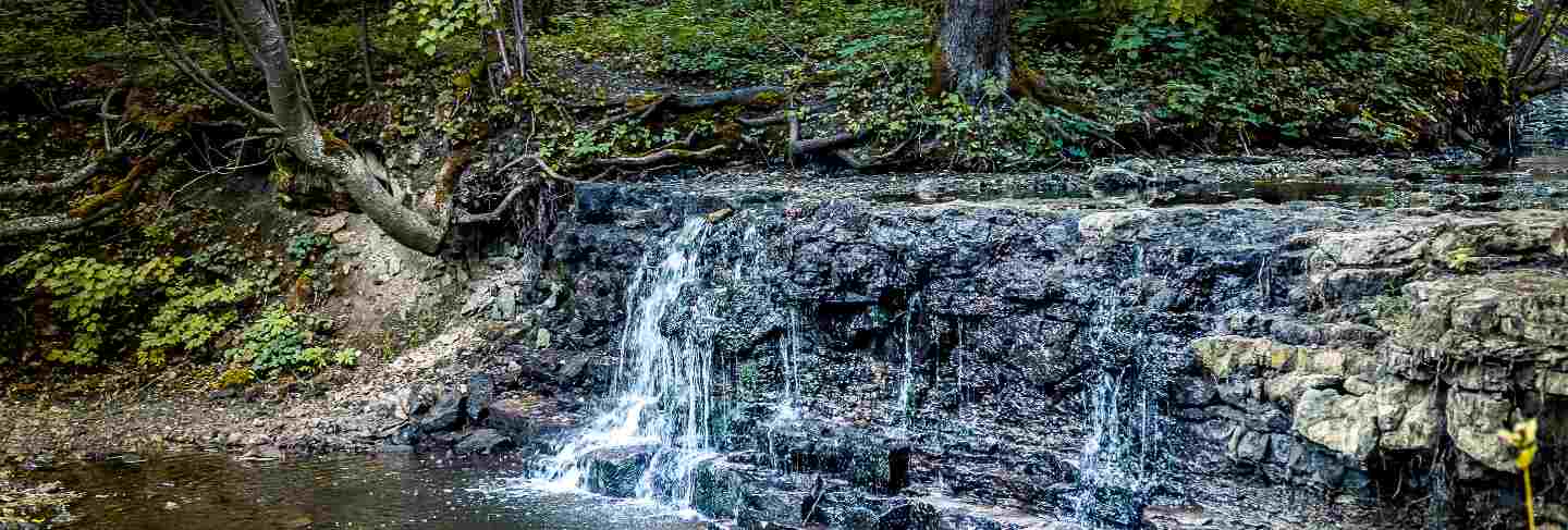 Waterfall falling down from a rock cascade. waterfall in summertime on small river in latvia, baltic states
